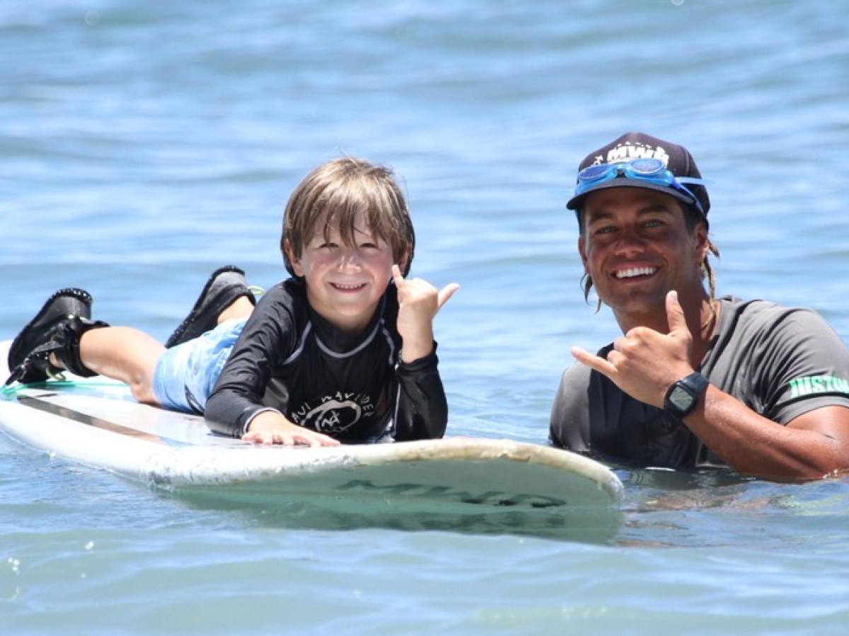 a young girl riding a wave on a surfboard in the water